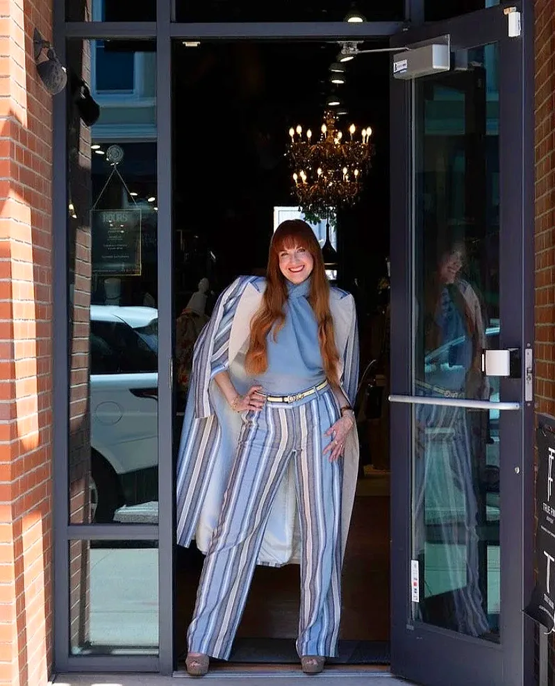 Woman in blue striped outfit standing in doorway of upscale restaurant entrance