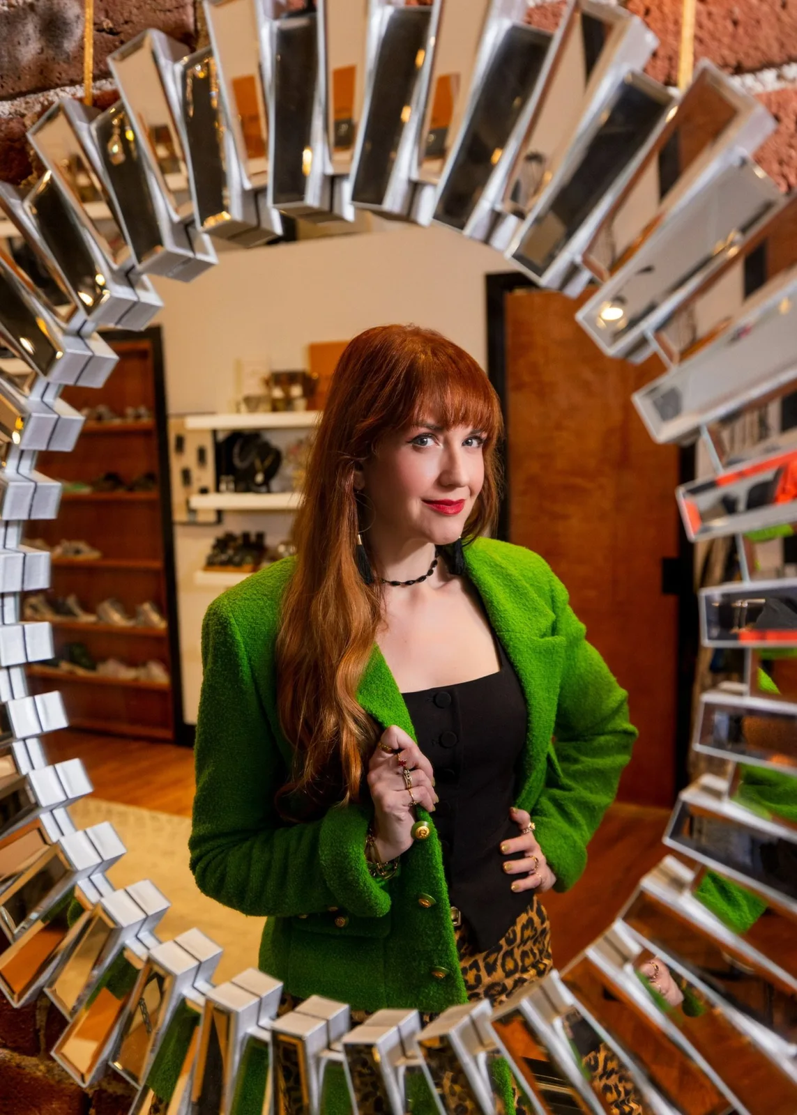 Woman in green blazer standing in center of circular display of product boxes in retail store